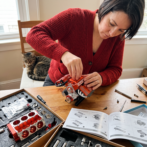 Photo client : une femme monte le kit PistonPlay à la table de la cuisine
