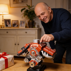Photo client : un homme lance le moteur PistonPlay sur le meuble du salon, cadeau déballé à côté