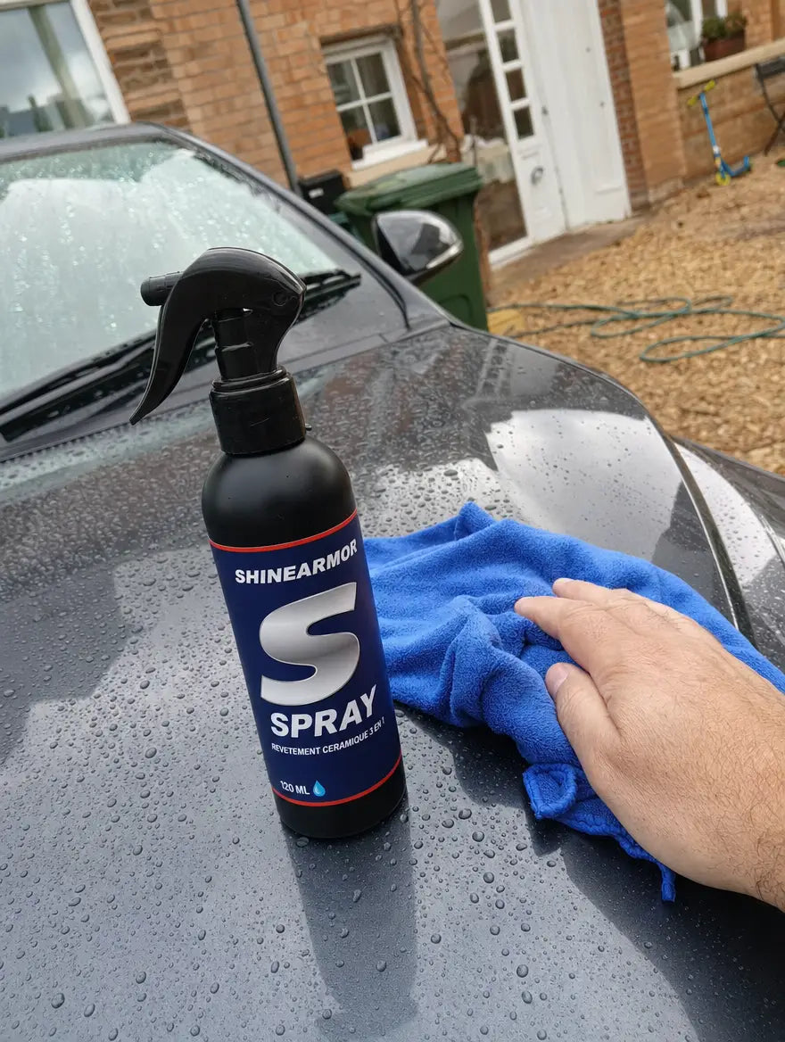 Photo client : flacon ShineArmor posé sur le capot d'une voiture grise dans une allée, l'eau perle