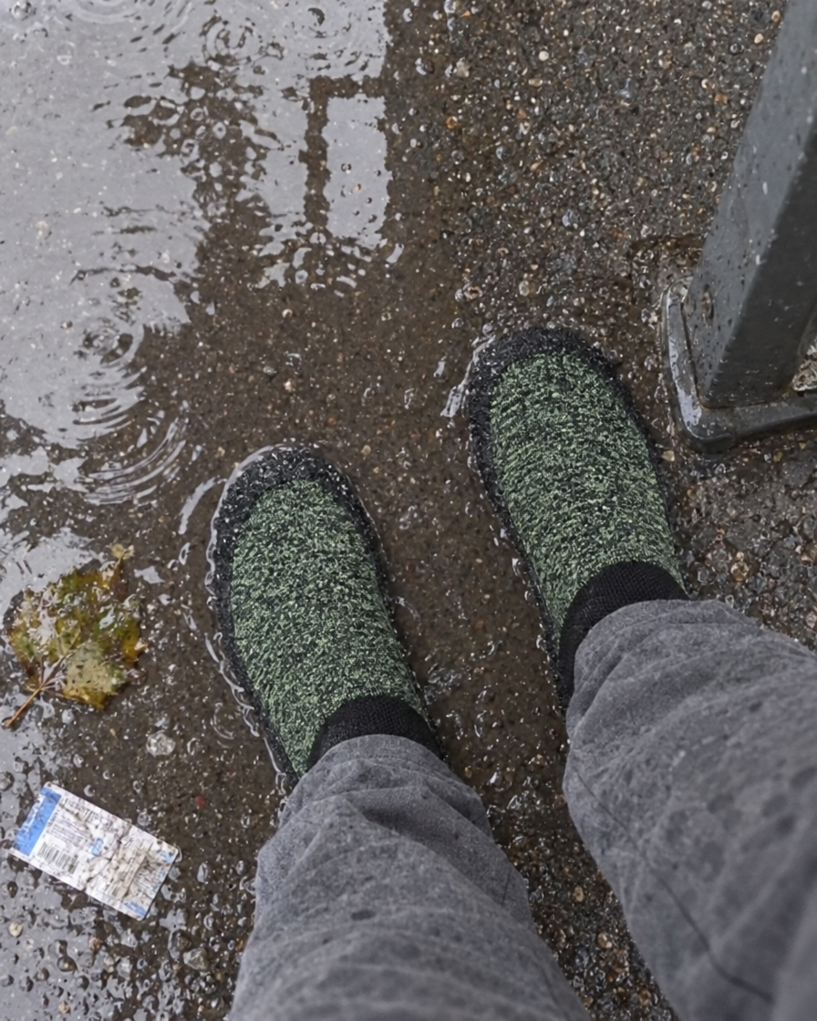 Photo client : SnugSoles vertes à l'arrêt de bus, trottoir mouillé