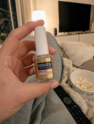 Photo cliente : flacon VitaNails tenu sur un canape le soir